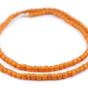 K&ouml;nnte beinhalten: Eine Kette aus orangefarbenen Glasperlen.