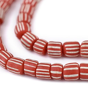 May include: A strand of red and white striped glass beads. The beads are cylindrical and have a glossy finish.