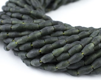May include: A strand of dark green glass beads with a faceted, elongated shape. The beads have a matte finish and are strung together to create a necklace or bracelet.
