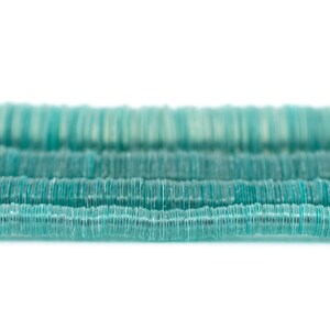 Op de afbeelding: Een streng turquoise blauwe glazen kralen, elke kraal is een platte schijf met een licht verhoogd midden.