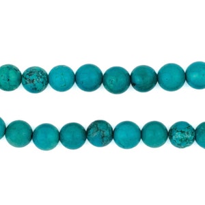 May include: A strand of turquoise blue round beads, arranged in two rows.