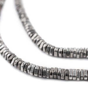 May include: A silver chain necklace made of small, flat, hexagonal beads.