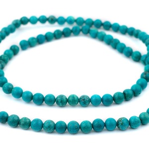 May include: A strand of turquoise beads, a popular choice for jewelry making. The beads are a vibrant blue-green color and have a smooth, polished finish.