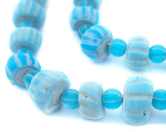 May include: A strand of light blue glass beads with white stripes. The beads are cylindrical and have a slightly irregular shape.