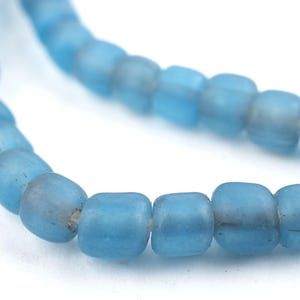 May include: A strand of light blue glass beads. The beads are round and have a frosted finish.