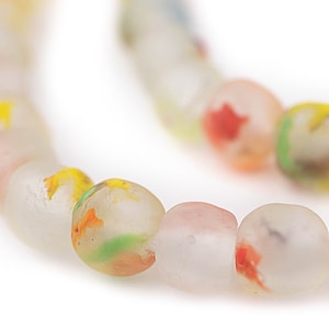 Könnte beinhalten: Eine Kette aus mattierten Glasperlen. Die Perlen sind rund und durchscheinend, mit farbenfrohen Flecken in Gelb, Rot, Grün und Rosa. Die Perlen sind aufgefädelt und bilden eine Halskette oder ein Armband.