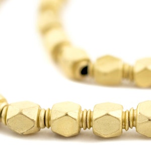 Puede incluir: Un collar de oro hecho de cuentas hexagonales. Las cuentas están conectadas por un fino alambre de oro.