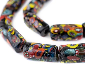 Puede incluir: Primer plano de un collar de cuentas de vidrio negras y rectangulares. Cada cuenta está decorada con un colorido patrón floral en rojo, amarillo, azul y verde. Las cuentas están ensartadas, mostrando su diseño único.