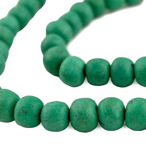 May include: A strand of green round beads, made of a textured material, strung together on a cord.