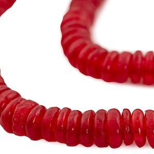 May include: A strand of red glass beads, each bead is shaped like a small, flat disc. The beads are strung together in a continuous loop.