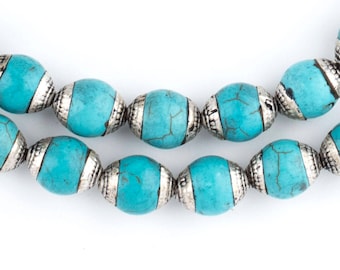 May include: A turquoise and silver beaded necklace with oval-shaped beads. The beads are made of turquoise stone and have a silver trim.