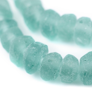 以下が含まれることがあります： フロスト仕上げのティールブルーのガラスビーズのストランド。ビーズは丸く、わずかに不規則な形をしています。