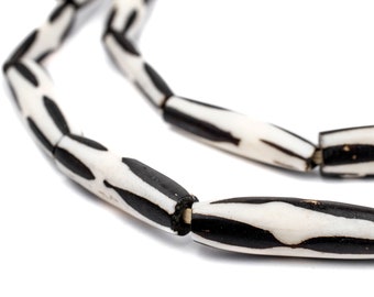 May include: A close-up of a black and white beaded necklace. The beads are cylindrical and have a striped pattern.