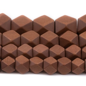 Puede incluir: Primer plano de una hebra de cuentas de madera marrón. Las cuentas son facetadas y tienen una forma geométrica.