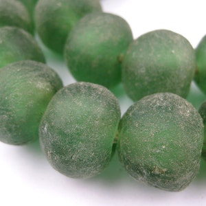 May include: A strand of green glass beads with a frosted finish. The beads are round and have a slightly irregular shape.