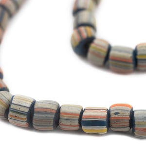 May include: Close-up of a necklace featuring cylindrical beads. The beads are primarily gray with horizontal stripes in various colors, including blue, orange, and yellow. The necklace has a dark blue string.