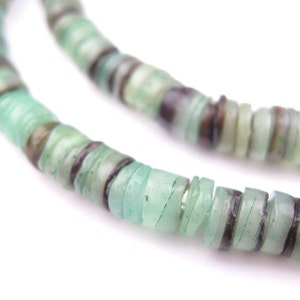 May include: Close-up of two strands of light green and brown disc-shaped beads. The beads have a translucent quality, with variations in color and texture. The beads are strung together, creating a necklace or bracelet.