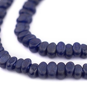 May include: A strand of dark blue oval-shaped beads. The beads are strung together to form a necklace.