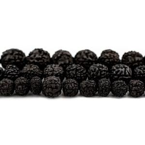 May include: A close-up shot of dark brown, textured beads. The beads are arranged in rows against a white backdrop. The beads have a rough, organic appearance, suggesting a natural material.