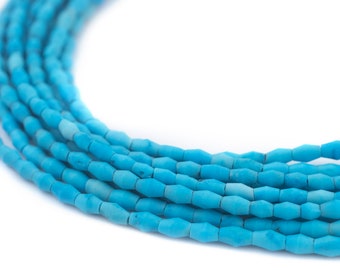 May include: Close-up of strands of turquoise-colored gemstone beads. The beads are small, cylindrical, and faceted, with a slightly irregular shape. The beads are strung together, forming a curved line against a white background. The color is a vibrant, saturated turquoise.