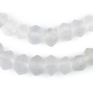 May include: A strand of opaque white glass beads with a faceted, hexagonal shape.