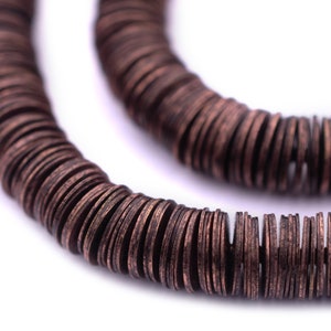 May include: A close-up of a copper-colored necklace made of stacked, round wooden beads.