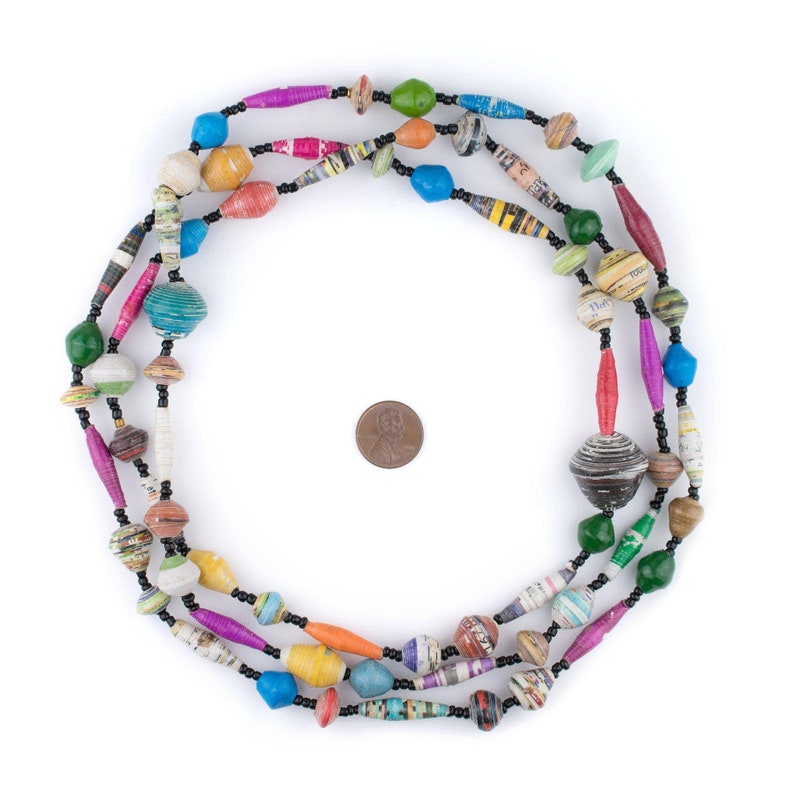 Pode incluir: Um colar colorido feito de contas de papel enrolado e contas pretas. As contas s&atilde;o de v&aacute;rias cores, incluindo vermelho, laranja, amarelo, verde, azul e roxo. O colar &eacute; enfiado em um cord&atilde;o preto.