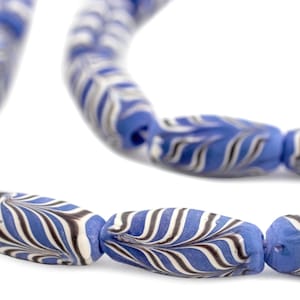 May include: A strand of blue and white glass beads with a swirling pattern. The beads are oval shaped and have a glossy finish.