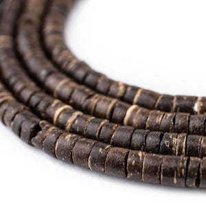 May include: A close-up of a strand of brown wooden beads. The beads are round and have a natural, rustic look.