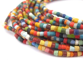 May include: A strand of colorful glass beads, each bead is a different color and has a slightly textured surface.