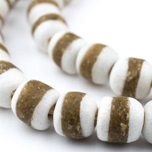 May include: A strand of white and brown striped beads. The beads are round and have a glossy finish.