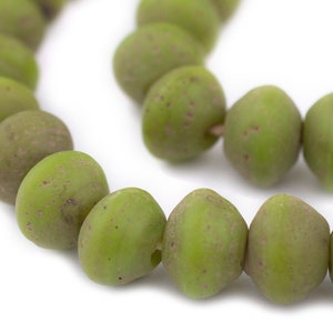 May include: A strand of green glass beads with a slightly textured surface. The beads are round and have a slightly irregular shape.