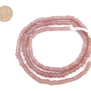 May include: A strand of dusty rose coloured glass beads. The beads are square shaped and have a matte finish.