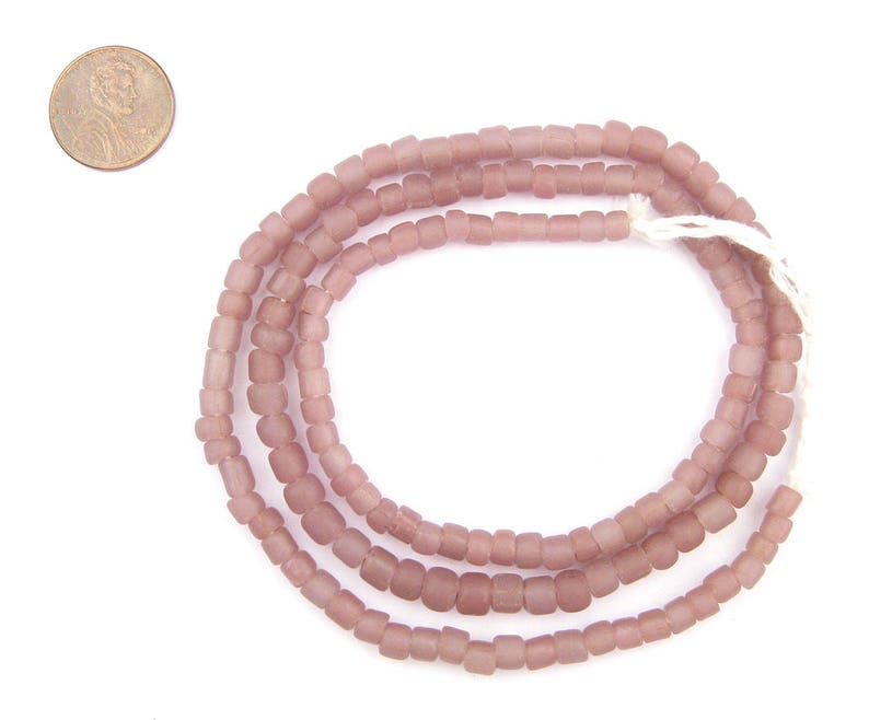 May include: A strand of dusty rose coloured glass beads. The beads are square shaped and have a matte finish.