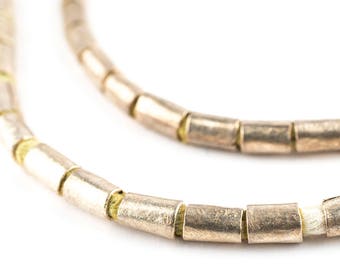 May include: A silver necklace with small, cylindrical beads. The beads are connected by a thin, white thread.