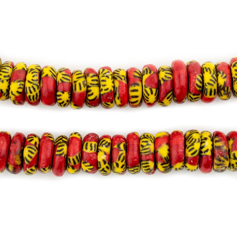 May include: Two rows of red and yellow glass beads with black geometric patterns. The beads are round and have a slightly irregular shape.