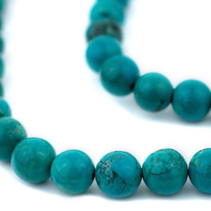 May include: A strand of turquoise beads, each bead is a vibrant blue-green color and has a smooth, round shape.