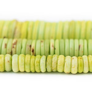 May include: A strand of light green and yellow round beads with a slightly rough texture.