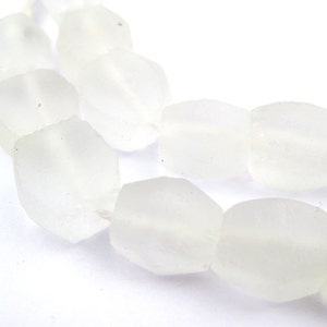 May include: A strand of opaque white glass beads, each bead is faceted and has a slightly irregular shape.