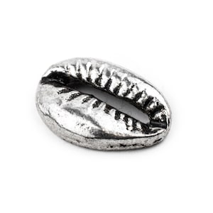 May include: A silver-colored cowrie shell charm with a detailed, textured surface.