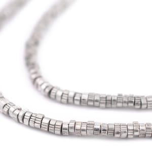 May include: A silver chain necklace made of small, round beads. The beads are stacked on top of each other, creating a textured look.