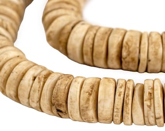 Op de afbeelding: Close-up van een ketting gemaakt van lichtbeige, platte, cirkelvormige kralen. De kralen hebben een natuurlijke, organische uitstraling met variaties in kleur en textuur. De ketting wordt getoond tegen een witte achtergrond.