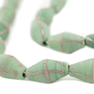 Op de afbeelding: Een streng groene glazen kralen met een wit en bruin kruispatroon. De kralen zijn ovaalvormig en hebben een glanzende afwerking.
