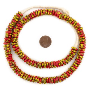 May include: A strand of red and yellow glass beads with a floral pattern. The beads are strung on a white cord and are approximately the size of a US penny.