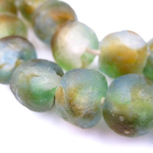May include: A strand of round, translucent glass beads in shades of green, blue, and brown. The beads have a mottled, marbled effect.
