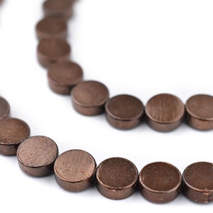 Peut inclure: Un brin de perles rondes brunes, en métal, avec une finition mate.