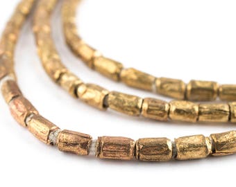 May include: A close-up of a gold-toned necklace made of small, cylindrical beads. The beads have a textured surface and are strung together on a thin cord.