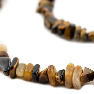 May include: A brown, gold, and black tiger's eye stone necklace with irregular shaped beads.