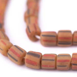May include: A close-up of a string of brown, red and black striped glass beads. The beads are cylindrical and have a matte finish.