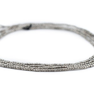 May include: A silver beaded necklace with multiple strands. The beads are small and round, creating a delicate and elegant look.
